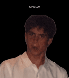 a man in a white shirt says " say what " in a black background