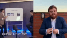 a man with a beard is standing next to a white board with korean writing