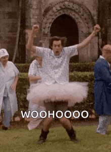 a man in a tutu is dancing in a park with a group of people .