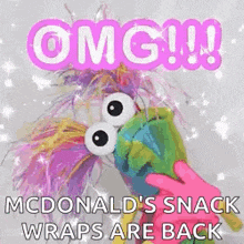 a mcdonald 's snack wraps are back and a stuffed animal is being held by a pink hand .