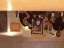 a group of people are upside down in a room with a picture on the wall