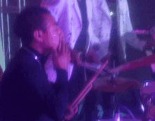 a man playing drums in a dark room