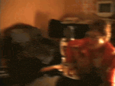 a woman in a red shirt is playing a saxophone in a dark room