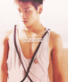 a young man wearing a tank top and a necklace with the words what do you see when you look at me