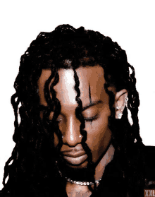 a man with dreadlocks and a tattoo on his face has xxl written on the bottom right