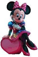 minnie mouse is sitting on a heart shaped object