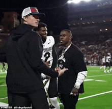 a football player with the number 2 on his jersey shakes hands with another player