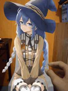 a blue haired anime girl wearing a witch hat is sitting on a chair