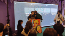 a group of people are gathered in front of a large screen that says twitter on it