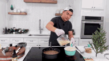 a man is pouring something into a bowl in a kitchen with the words made in animatica on the bottom