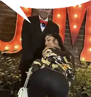 a man in a tuxedo stands next to a woman in a camo jacket