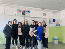 a group of people posing for a picture in a classroom with a sign that says yks