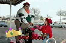 a man in a clown costume is standing next to a little girl in a cowboy outfit on a carousel .