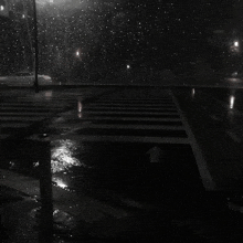 a black and white photo of a rainy street with an arrow pointing to the right