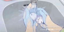 a person is washing their hands in a sink while wearing gloves