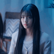 a woman with long black hair is wearing a white shirt