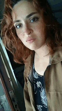 a woman with red hair and freckles is wearing a shirt that says coca cola on it