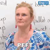 a woman is sitting in front of a white board and the word pfft is on her shirt