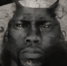 it is a black and white photo of a man with horns on his head .