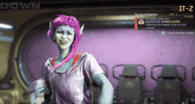 a woman with pink hair is standing in front of a screen that says down and it-z