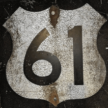 the number 61 is on a cracked road sign