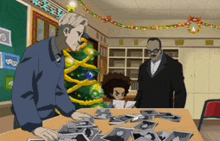 a man in a blue jacket is looking at a pile of pictures on a table in front of a christmas tree