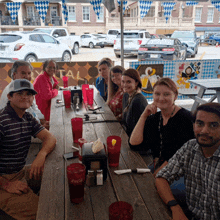 a group of people sit at a table with coca cola glasses