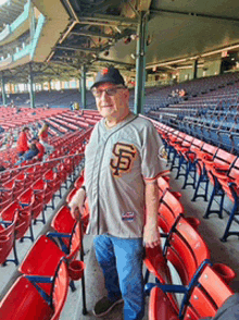 a man in a san francisco giants jersey stands in the stands