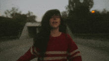 a man wearing a red and white striped sweater looks up at the sky