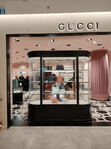 the inside of a gucci store with a display of handbags