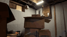 a stack of cardboard boxes in a basement including one labeled sparkle