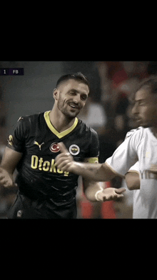 a soccer player wearing a black shirt with otokey on it