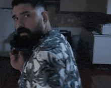 a man in a hawaiian shirt is holding a gun