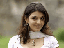 a woman wearing a white top and a necklace with a pendant on her neck