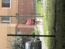 a woman wearing a pink shirt that says ' i love you ' on it walks behind a fence