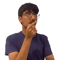 a man wearing glasses and a blue shirt holds his finger to his lips