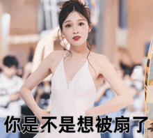 a woman in a white dress stands in front of a sign with chinese characters