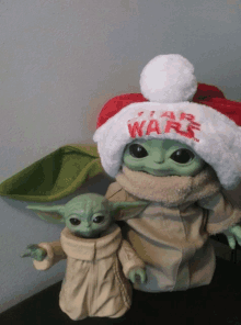 a baby yoda wearing a santa hat that says star wars on it