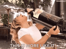 a woman is holding a bottle of plume wine and says this is more like it