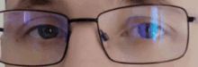 a close up of a person wearing glasses with a blue reflection