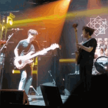 a man playing a guitar on a stage in front of a sign that says ' a ' on it