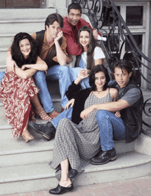 a group of people are posing for a picture on a set of steps