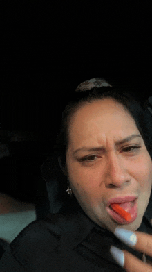 a woman is sticking her tongue out while sitting in a car .