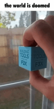 a person is holding a building tools f3x cube in their hand