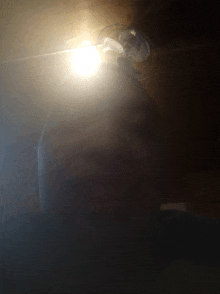 a person 's head is visible in the dark with a light shining on it