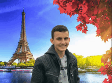 a young man stands in front of the eiffel tower wearing a black jacket