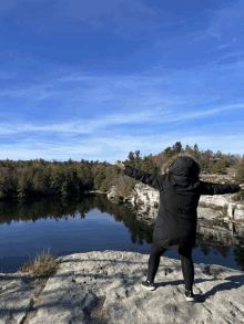 a person standing on a rock overlooking a lake