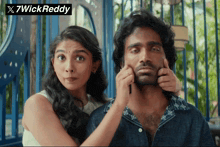 a woman putting her hand on a man 's face with a 7wick reddy logo in the background