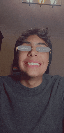 a young man wearing sunglasses with vibes written on them