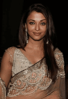 a close up of a woman wearing a saree with pearls and sequins .